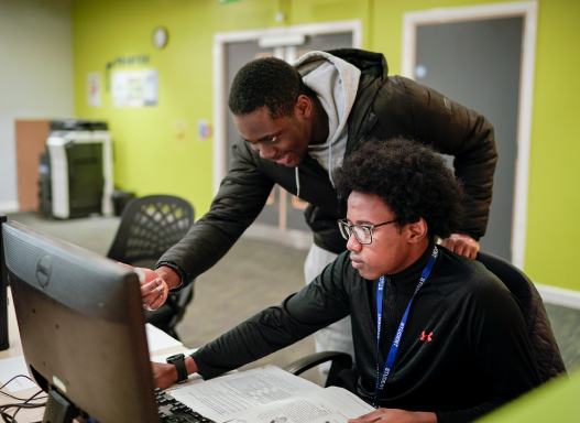 Picture of two of our students using a PC